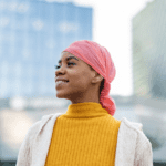 Smiling Black woman wearing a pink head scarf