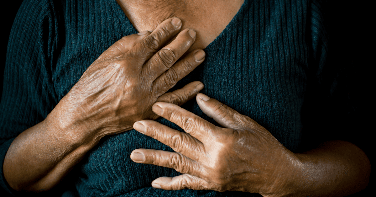 The image depicts a close-up of a woman's hands clasped against her chest.