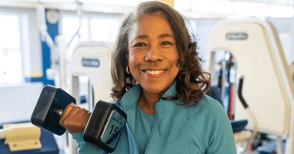 Community member, Ms. Gail, holding a gym weight