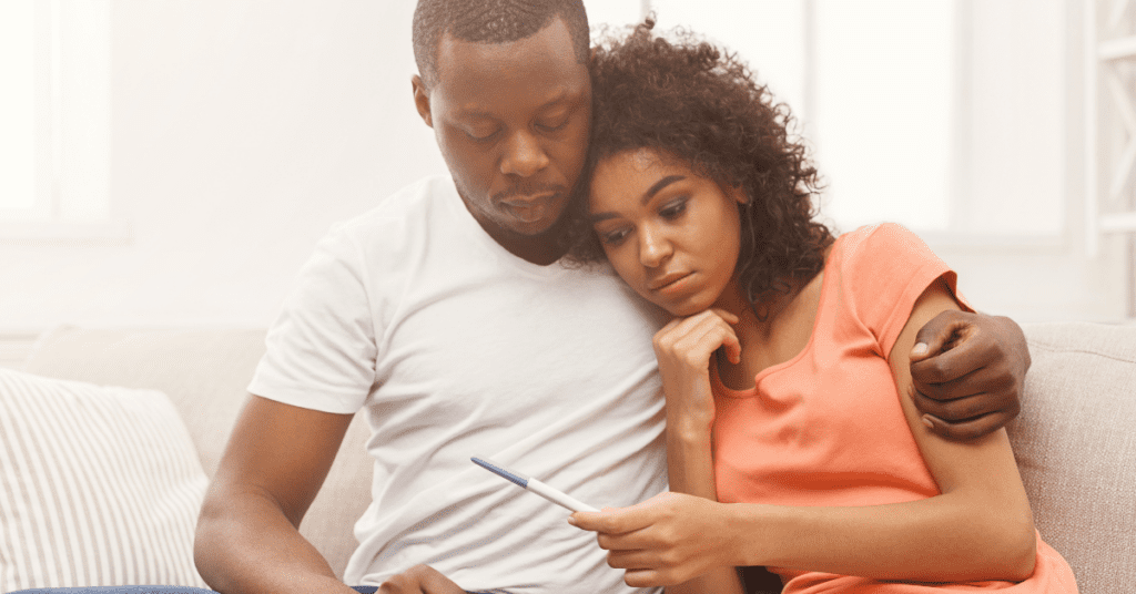 Black couple looking over a pregnancy test