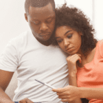 Black couple looking over a pregnancy test