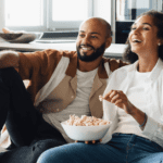 Couple eating popcorn on the couch