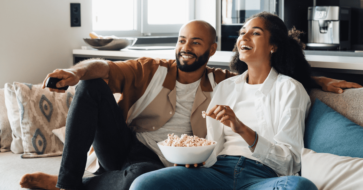 Couple eating popcorn on the couch