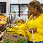 Senior Black woman in the grocery store buying bananas