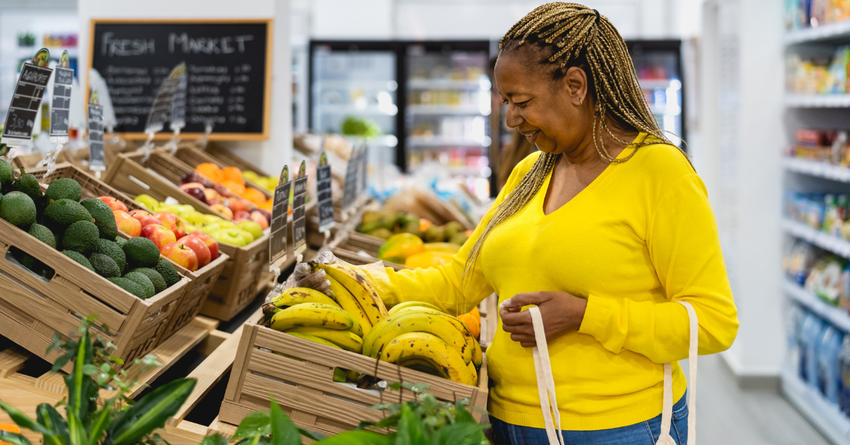 Senior Black woman in the grocery store buying bananas