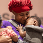 Black mom holding her baby girl and boy on each arm