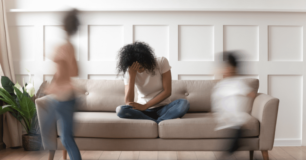 Woman sitting on the couch with her head in her hand