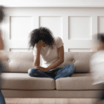 Woman sitting on the couch with her head in her hand