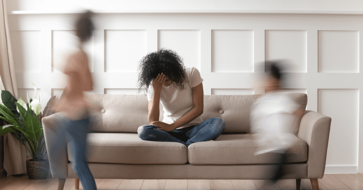 Woman sitting on the couch with her head in her hand