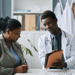 Black female patient and male doctor in lab coat discussing lab results
