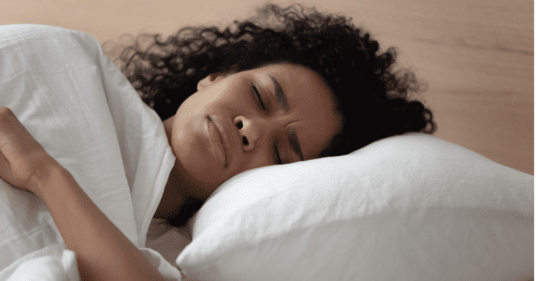 4 Types of Lung Cancer You Should Know About 1 Close-up of woman laying on a pillow with a distressed expression and her eyes closed