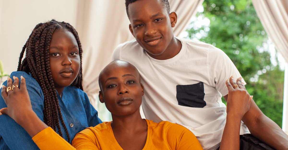 Black woman with shaved head sitting between her two children