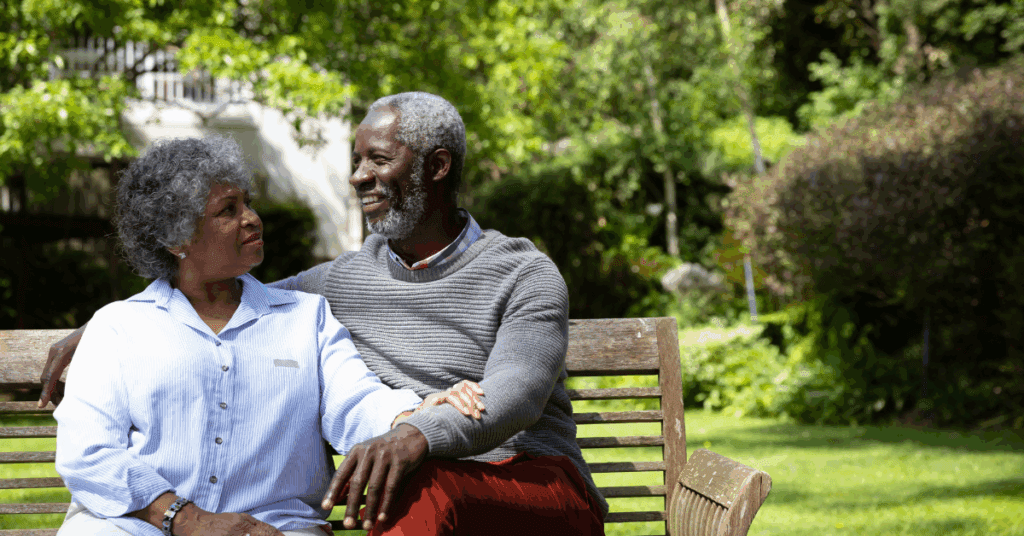 Elderly Black couple sitting on a bench in the park