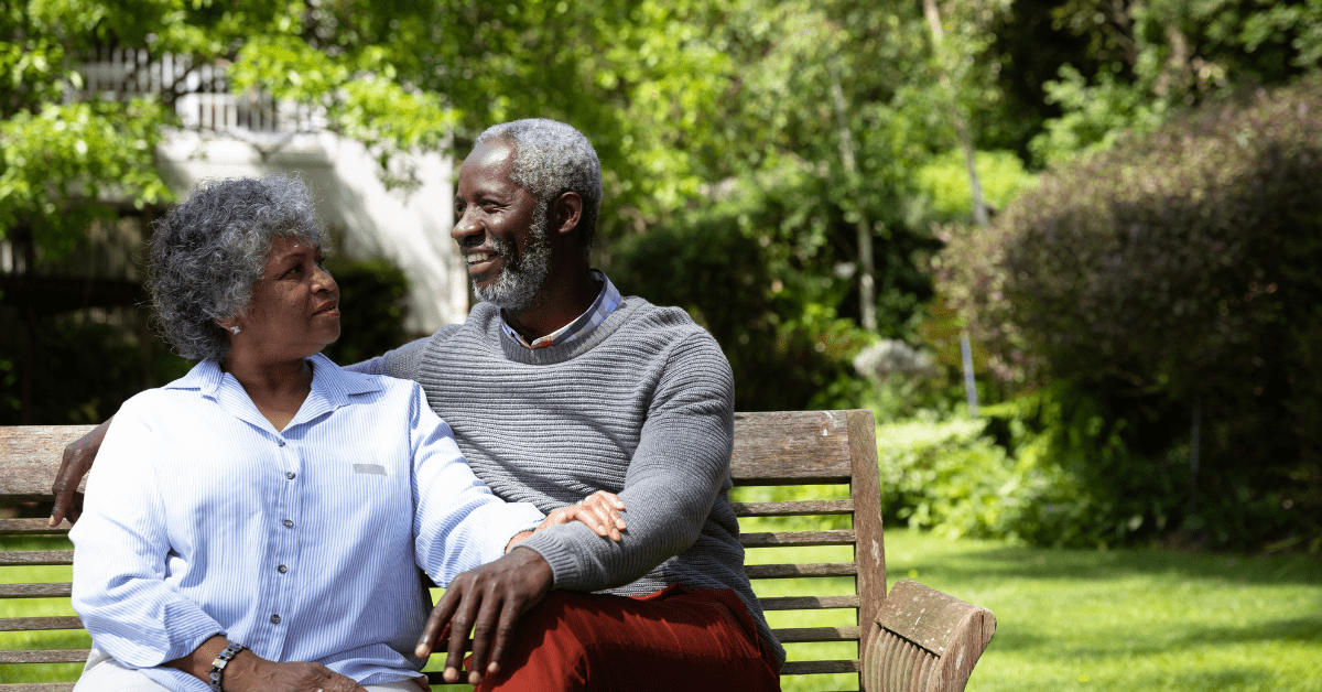 Elderly Black couple sitting on a bench in the park