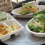These Chipotle Swaps Will Save Your Gut & Skin 3 Burrito bowl, tacos, quesadilla, and a bag of chips from Chipotle sitting on a table