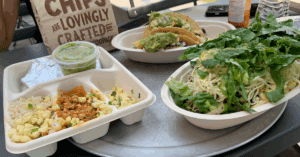 Burrito bowl, tacos, quesadilla, and a bag of chips from Chipotle sitting on a table