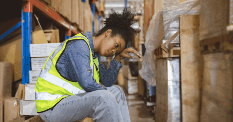 Meet NOWINCLUDED’s New Chatbot: NIA 2 Tired, stressed woman worker working in warehouse cargo inventory industry.