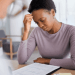 Young Black woman stressed about medical bills in hospital