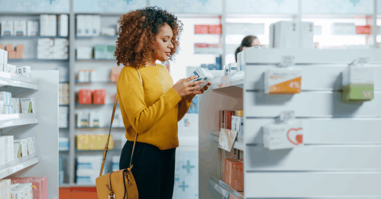 5 Benefits of Using Aloe Vera 1 Black woman in a yellow sweater looking at a box of medications at the pharmacy