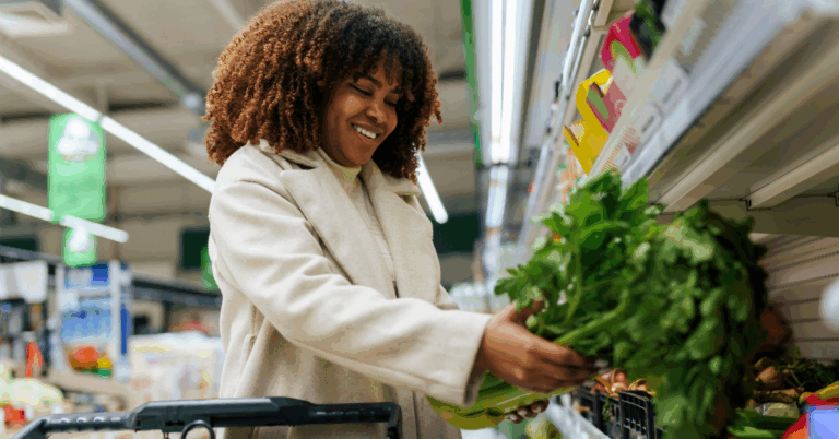 Dr. David Hicks on the Battle Against COVID-19 Misinformation 1 Smiling Black woman buying greens from the refrigerated section in the supermarket.