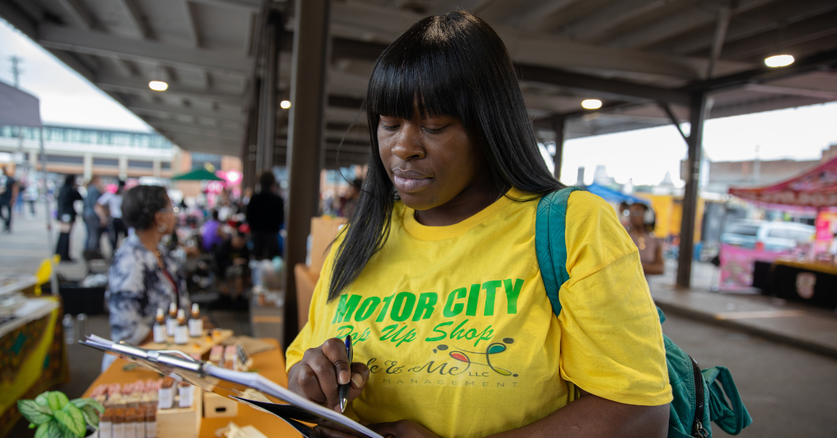 African American woman in a yellow shirt filling out health survey at community event
