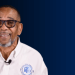 Dr. Wright, founder of the “We Can Win Foundation”, in front of a blue wall, talking about prostate cancer