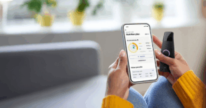 Close-up of someone holding Lumen, a gut health device, and tracking the results on their phone