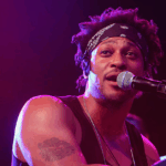 What D’Angelo’s Passing Reveals About Pancreatic Cancer 4 Neo-soul singer, D’Angelo, singing into a mic on stage before his passing from pancreatic cancer