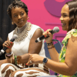 Tiffany Whitlow, co-founder and CDO, Acclinate, and social media influencer and ulcerative colitis thriver, Victoria Tyler, sit on a stage holding microphones while participating in a panel discussion at BWE.
