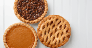 Holiday desserts that may raise your blood sugar; pecan pie, sweet potato pie, and apple pie, against a white background