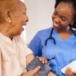 Black female healthcare professional monitoring the high blood pressure of an older woman