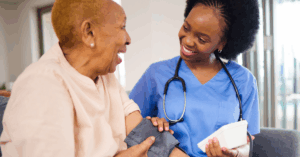 Black female healthcare professional monitoring the high blood pressure of an older woman
