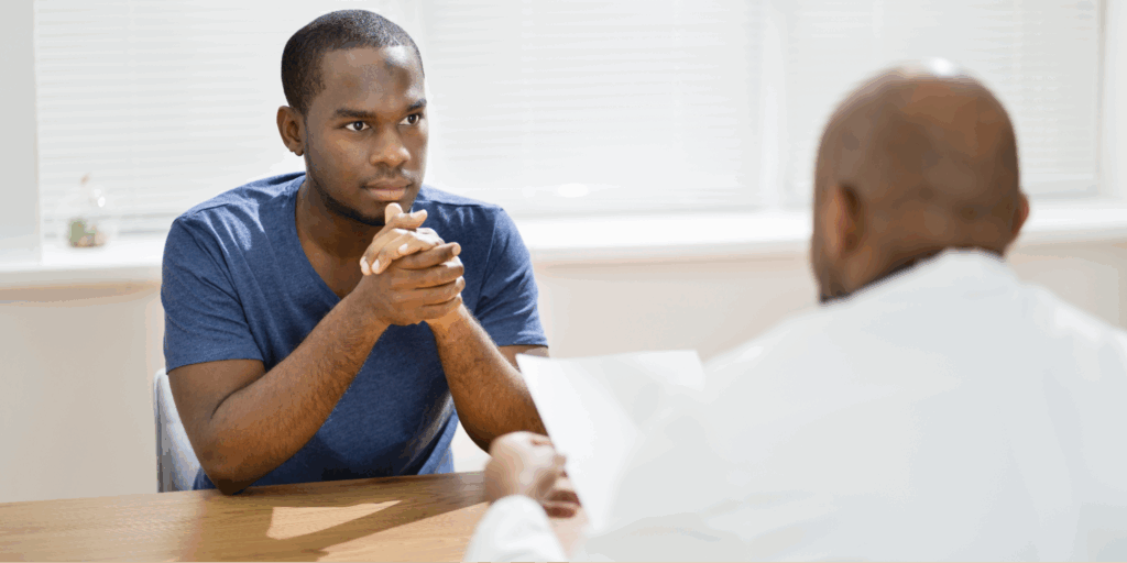 A Black man reviewing medical documents about GFR score and kidney health function with a Black male physician.