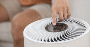 Close up of hand pressing power button air purifier for clean air in house for good health.