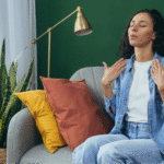 A Hispanic woman in a denim shirt using mindful breathing exercises to lower inflammation and stress in the body.