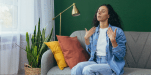 A Hispanic woman in a denim shirt using mindful breathing exercises to lower inflammation and stress in the body.