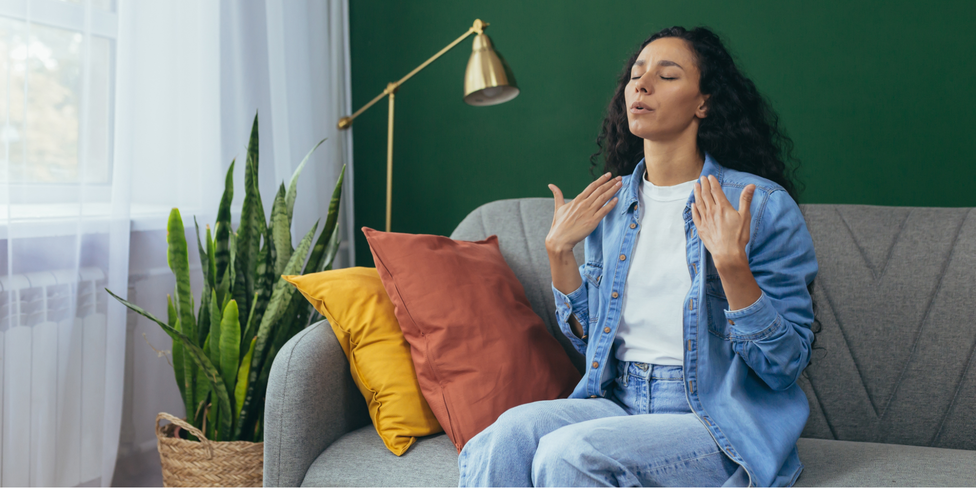 A Hispanic woman in a denim shirt using mindful breathing exercises to lower inflammation and stress in the body.