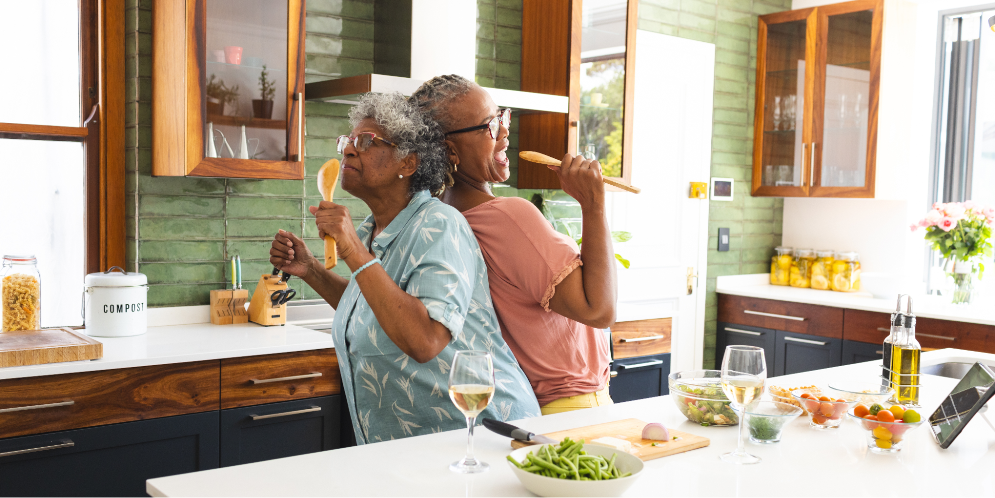Two Black women enjoying time together in the kitchen while cooking heart-healthy Southern recipes that lower cholesterol.