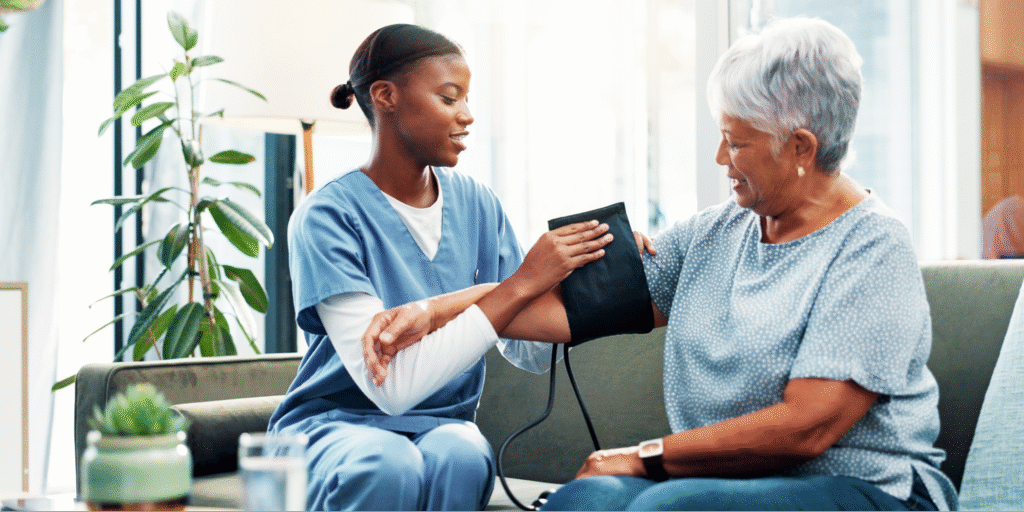 A close-up of a caregiver using a blood pressure cuff on a senior patient to assist in managing her blood pressure levels to protect against kidney failure.
