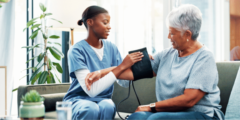 A close-up of a caregiver using a blood pressure cuff on a senior patient to assist in managing her blood pressure levels to protect against kidney failure.