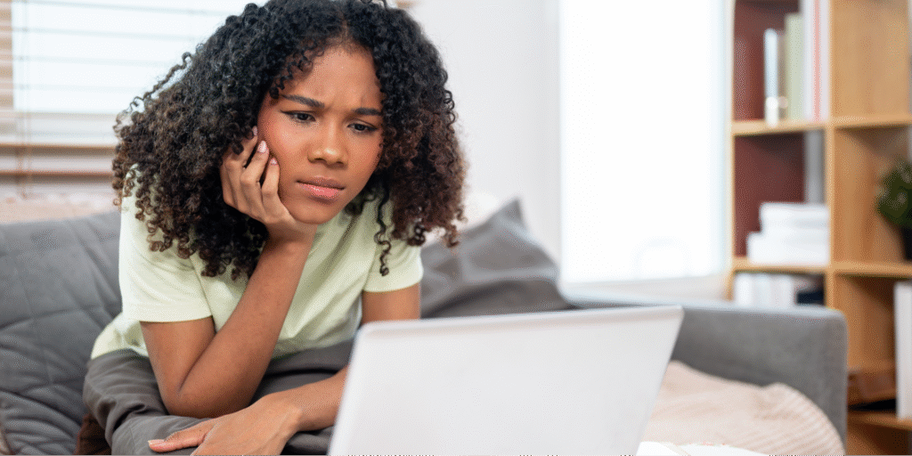A young black woman carefully reviewing medical notes from her visit via a patient portal.