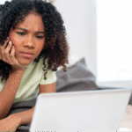 A young black woman carefully reviewing medical notes from her visit via a patient portal.