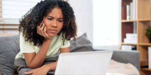 A young black woman carefully reviewing medical notes from her visit via a patient portal.