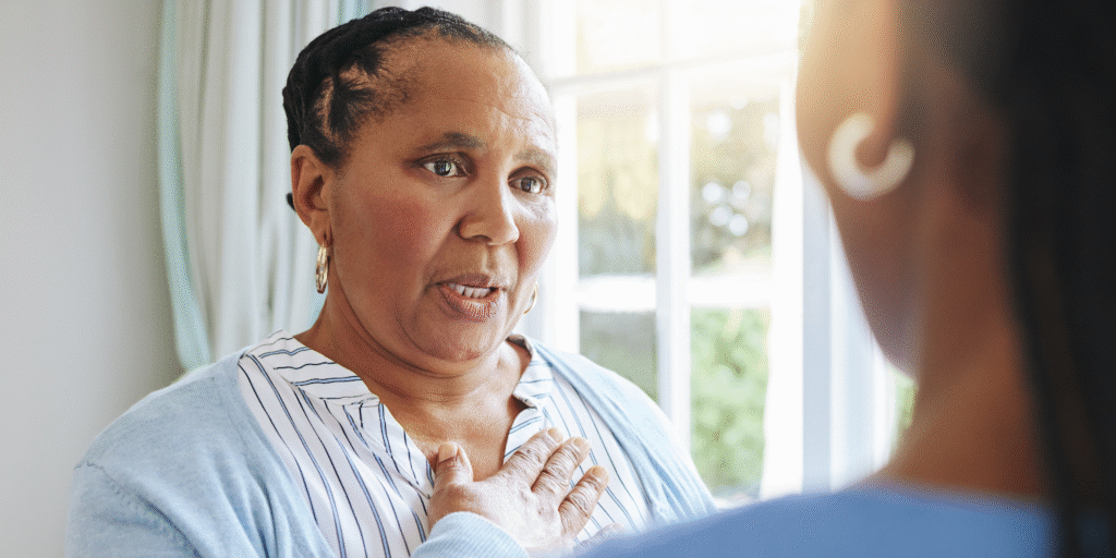 An older Black woman describing physical symptoms of heart failure to a caregiver.