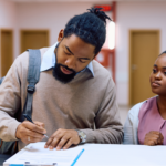 A Black family standing at a clinic reception desk, where the father is filling out medical paperwork for prostate cancer treatment.
