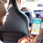 Close-up of a Black woman&rsquo;s hand holding a phone with a ride share GPS, getting free transportation to her radiation appointment.
