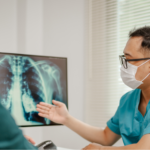 Close-up of doctor pointing to a patient’s lung cancer screening results.