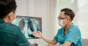 Close-up of doctor pointing to a patient&rsquo;s lung cancer screening results.