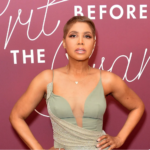 Grammy-winning singer, Toni Braxton, standing in front of a mauve wall with her hands on her hips following her lupus story news.