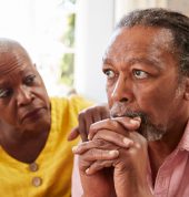 Senior Woman Comforting Man With Depression At Home